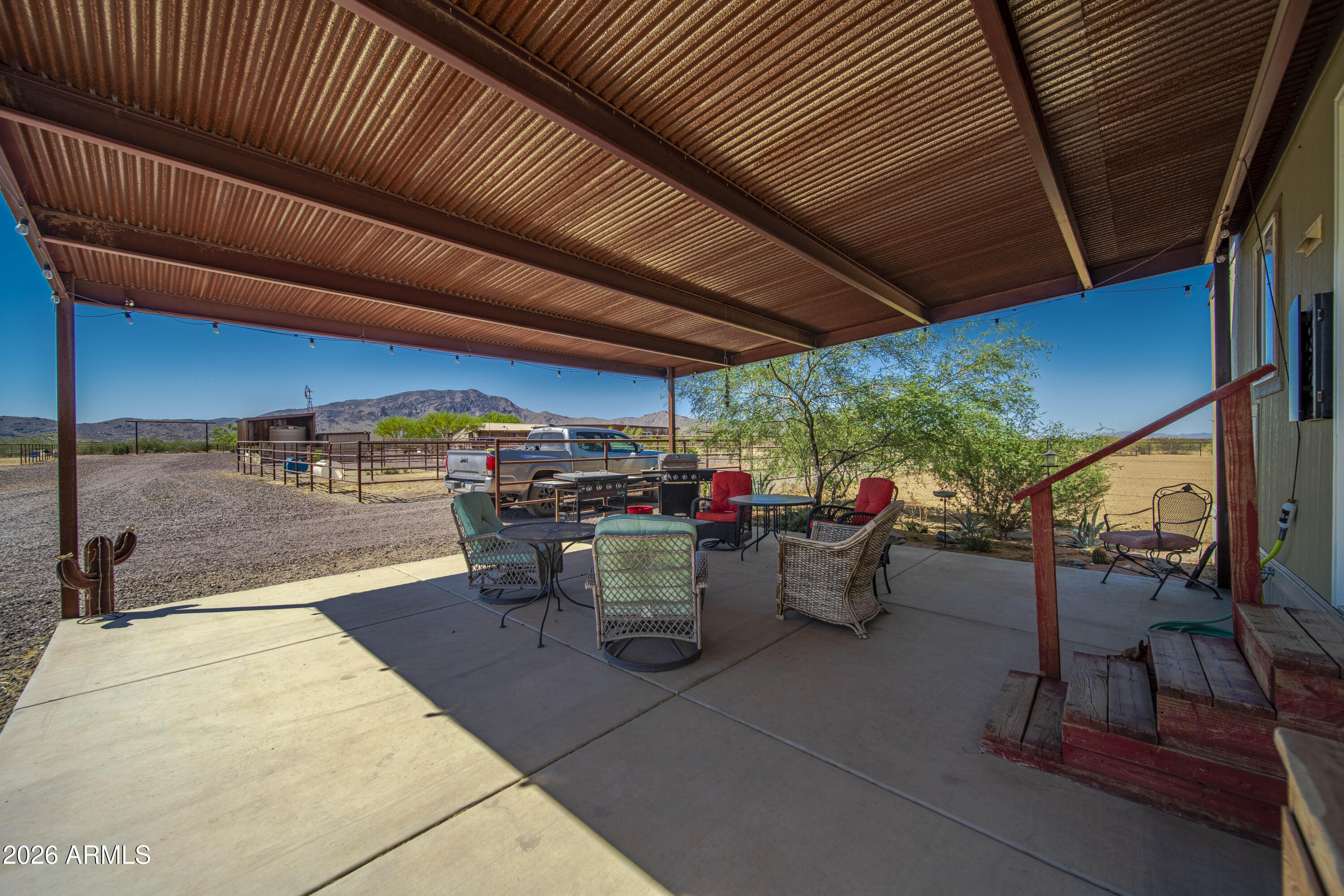 52510 Williams Road Aguila, AZ 85320 - Photo 33 of 62 a view of a patio with table and chairs barbeque potted plants and large tree