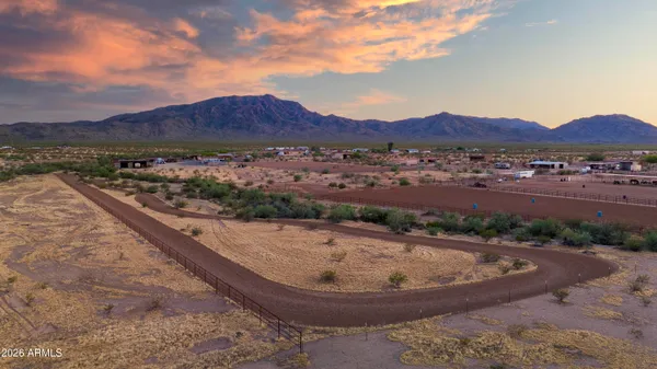 a view of a house with fountain plants and large trees