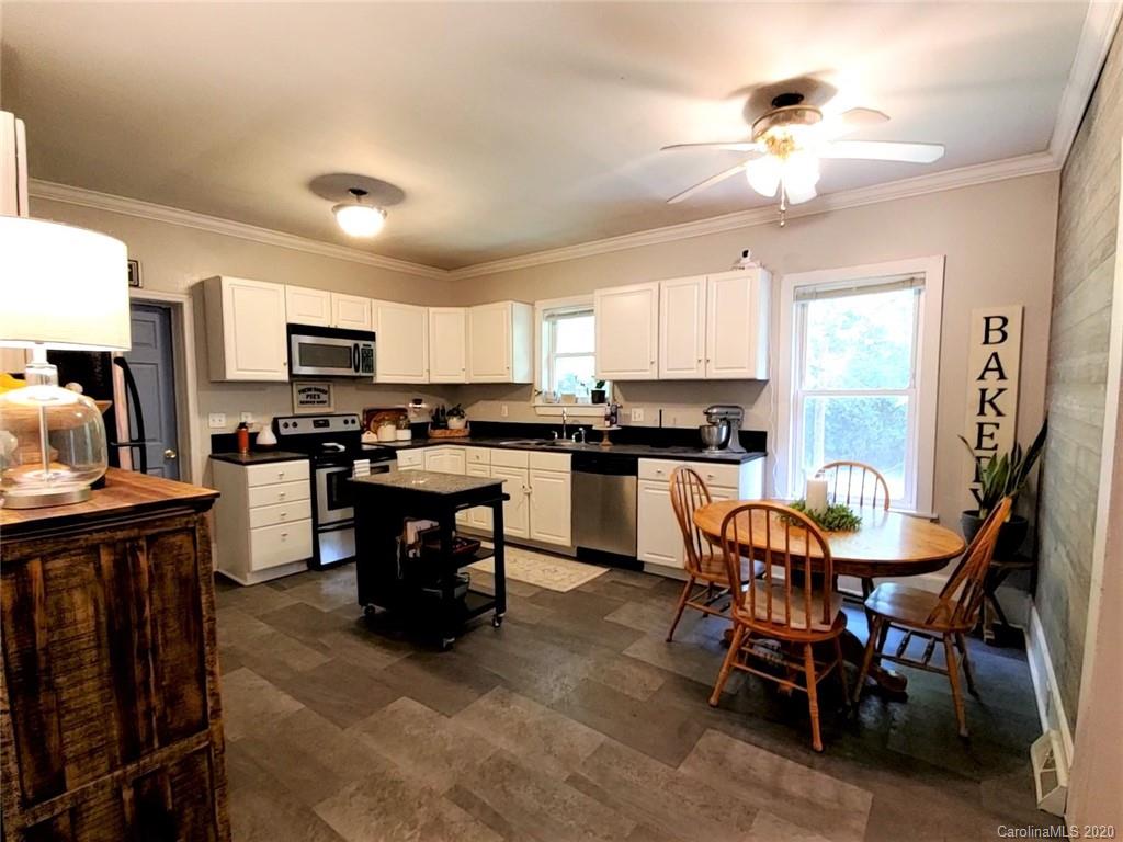 1602 Griffith Road Monroe, NC 28112 - Photo 14 of 45 a kitchen with stainless steel appliances a dining table chairs refrigerator and cabinets