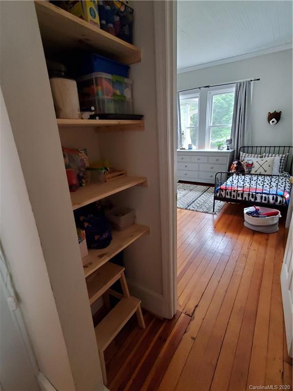 1602 Griffith Road Monroe, NC 28112 - Photo 34 of 45 a living room with baby crib furniture and a wooden floor