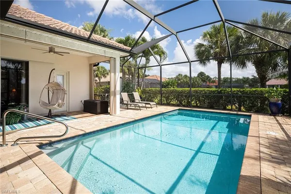 a view of a backyard with a patio and swimming pool