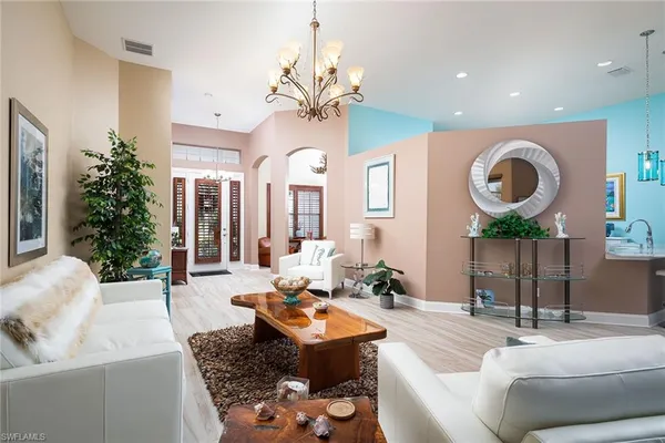 a living room with furniture a potted plant and a large window
