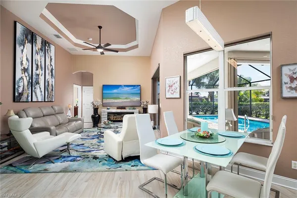 a living room with furniture a flat screen tv and a large window