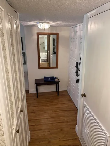 a view of a hallway with wooden floor and staircase