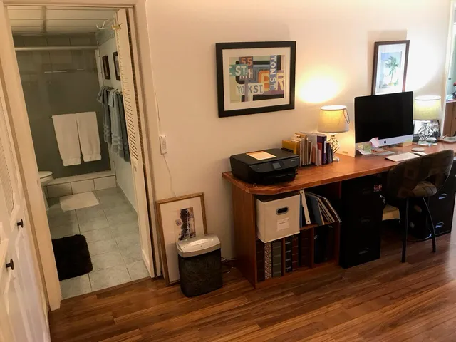 a view of a workspace with furniture and bathroom