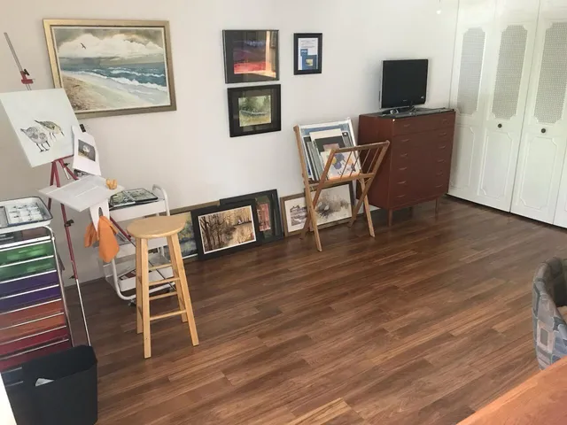 a view of a workspace with furniture and wooden floor