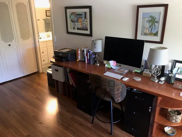 a view of a workspace with furniture and wooden floor