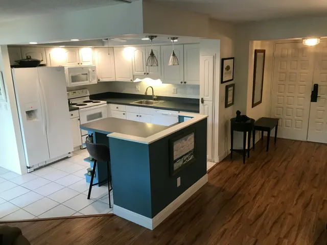 a kitchen with a stove a refrigerator and wooden floor