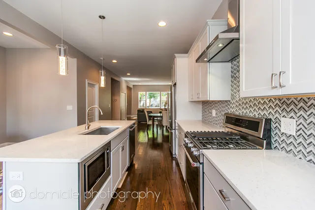 a kitchen that has a sink a stove and chairs
