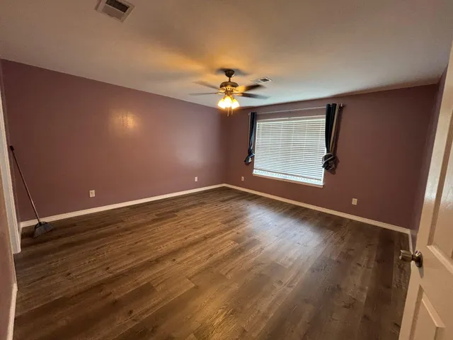 wooden floor in an empty room with a window