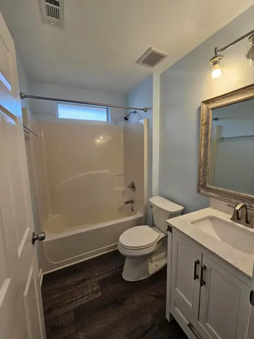 a bathroom with a sink a toilet a mirror and shower