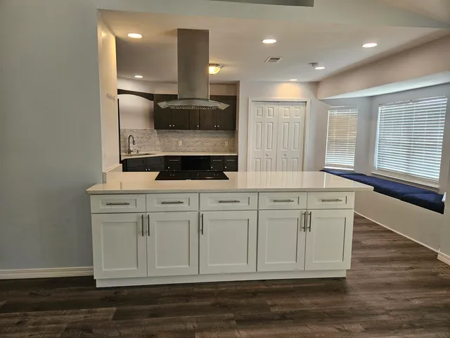 a kitchen with white cabinets and sink
