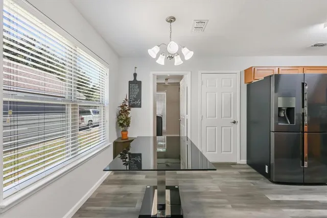 a view of a refrigerator in kitchen and dining area with chandelier