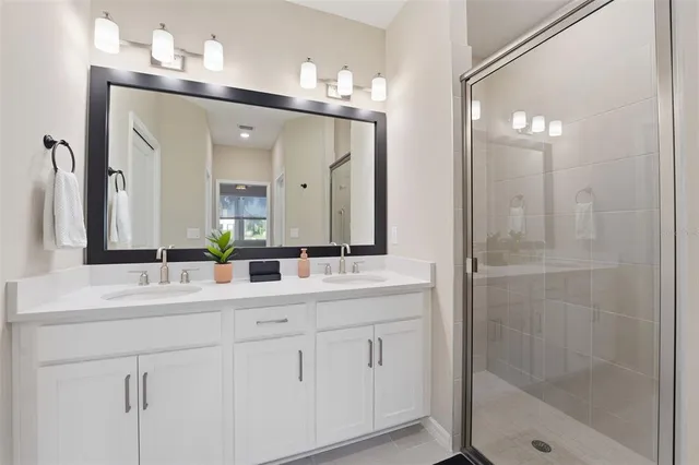 a bathroom with a double vanity sink mirror and shower