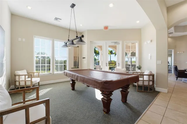 a room with furniture pool table and windows