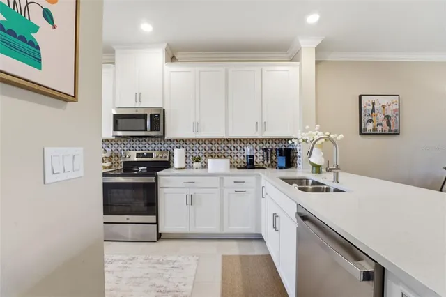 a kitchen with stainless steel appliances a stove sink microwave and cabinets