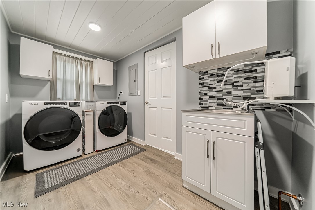 6873 Lake Road Madison, OH 44057 - Photo 15 of 29 Laundry area with cabinet space, separate washer and dryer, light wood finished floors, electric panel, and wooden ceiling