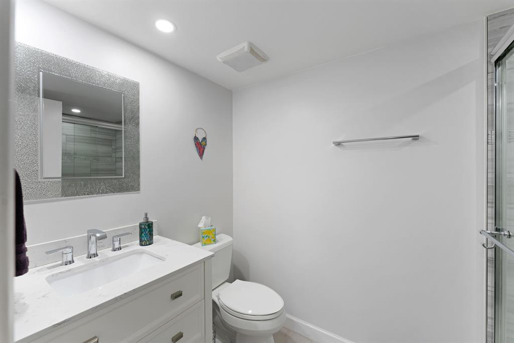 615 North Riverside Drive, Unit 502 Pompano Beach, FL 33062 - Photo 16 of 43 a bathroom with a granite countertop sink a toilet and a mirror