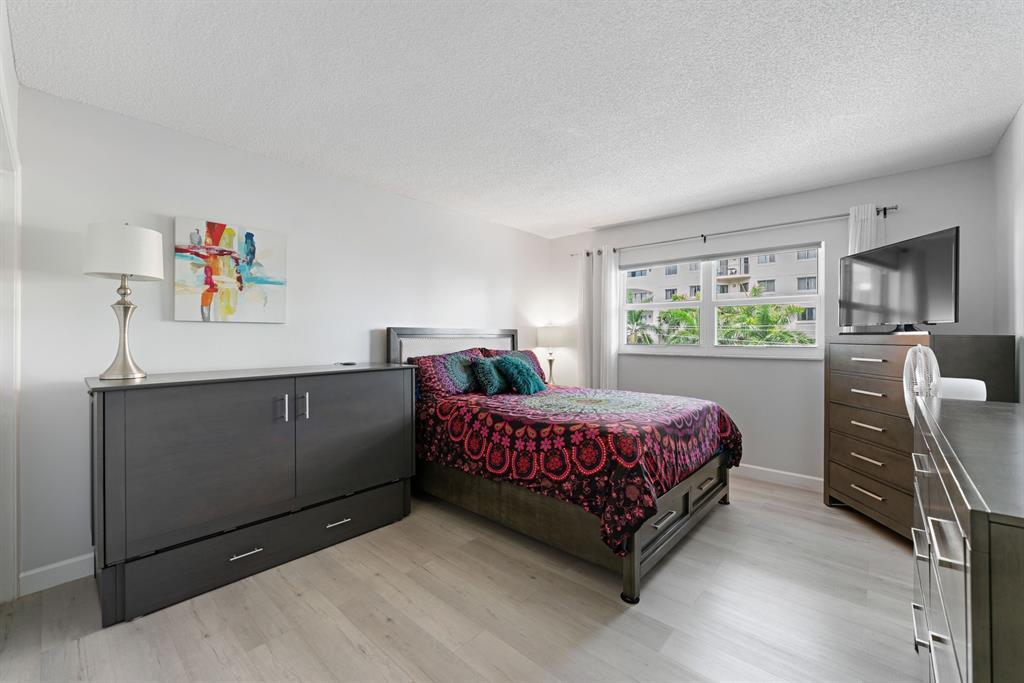615 North Riverside Drive, Unit 502 Pompano Beach, FL 33062 - Photo 18 of 43 a bedroom with a bed and a dresser next to it
