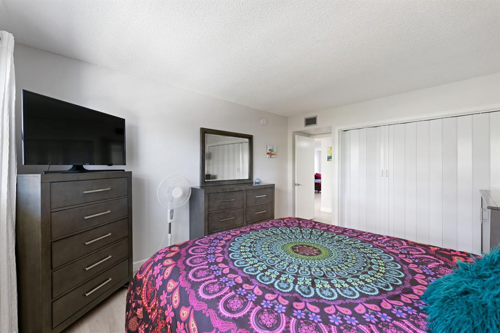 615 North Riverside Drive, Unit 502 Pompano Beach, FL 33062 - Photo 19 of 43 a bedroom with a bed and a flat screen tv