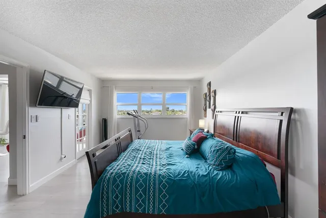 a living room with stainless steel appliances furniture a rug and a kitchen view