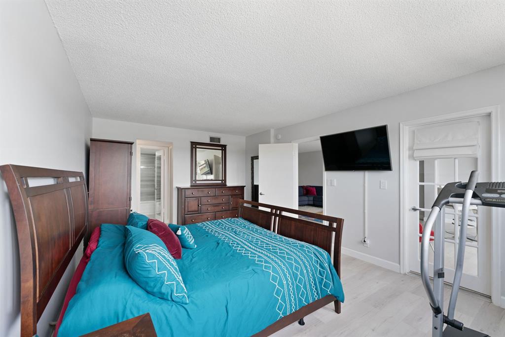 615 North Riverside Drive, Unit 502 Pompano Beach, FL 33062 - Photo 22 of 43 a bedroom with a bed and a flat screen tv