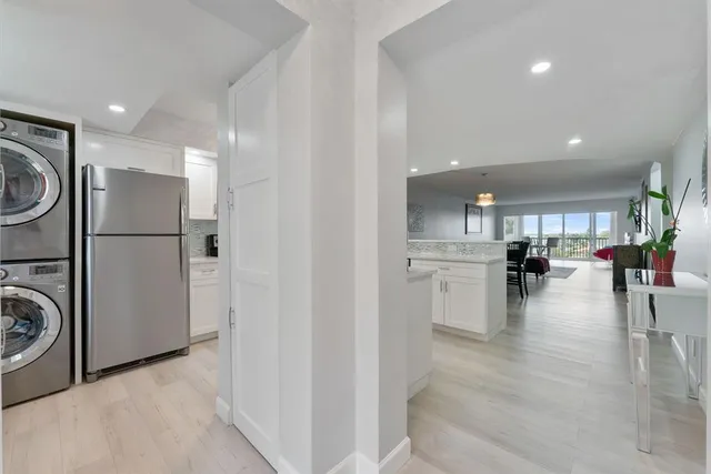 a view of a kitchen with a refrigerator and wooden floor