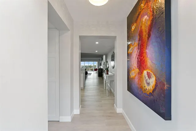 a view of a hallway with wooden floor and living room