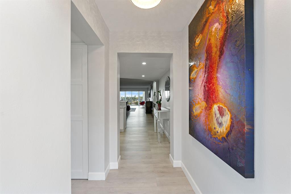 615 North Riverside Drive, Unit 502 Pompano Beach, FL 33062 - Photo 6 of 43 a view of a hallway with wooden floor and living room