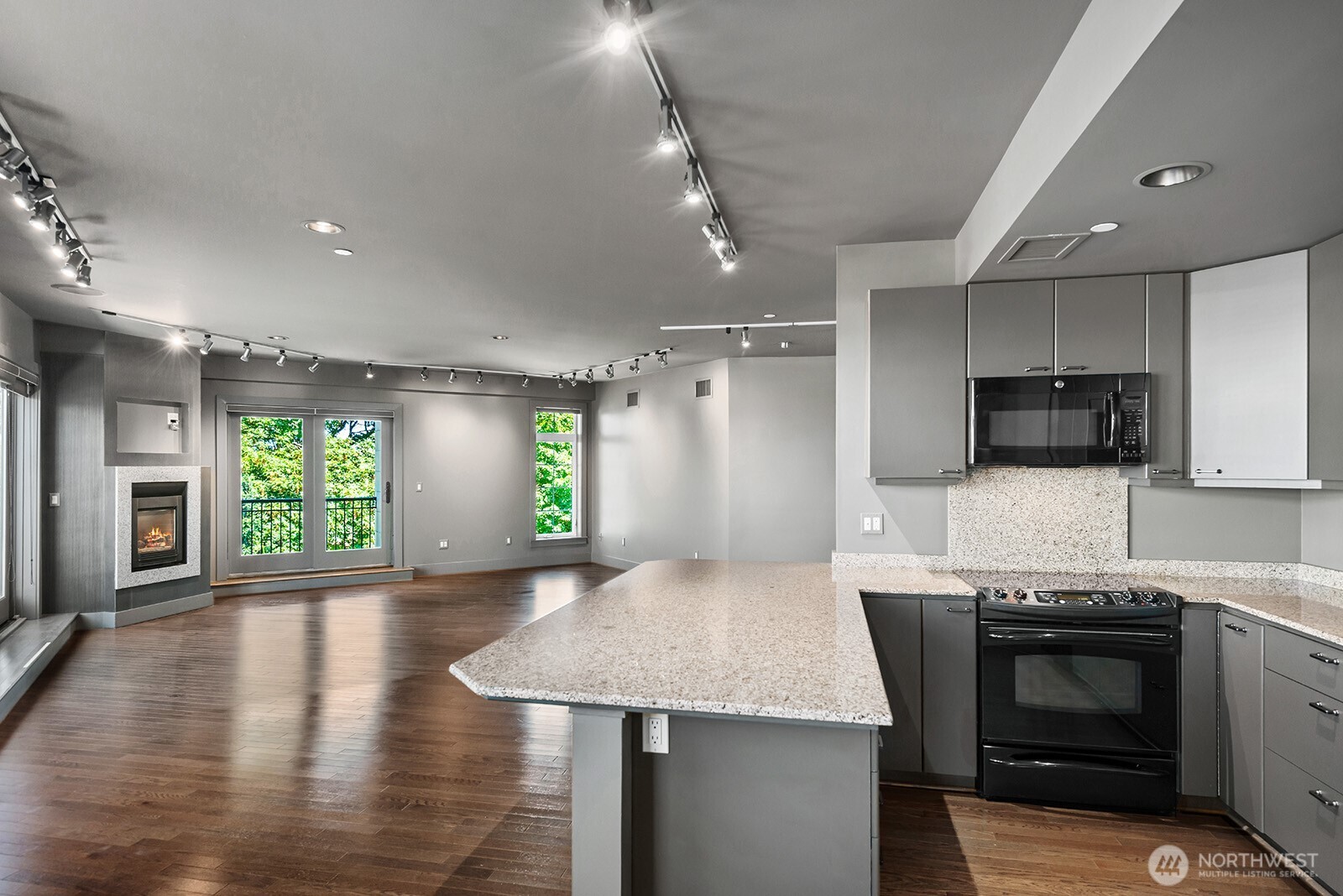 745 Bellevue Avenue East, Unit 402 Seattle, WA 98102 - Photo 18 of 39 a kitchen with stainless steel appliances granite countertop a sink a stove a microwave a refrigerator cabinets and living room view
