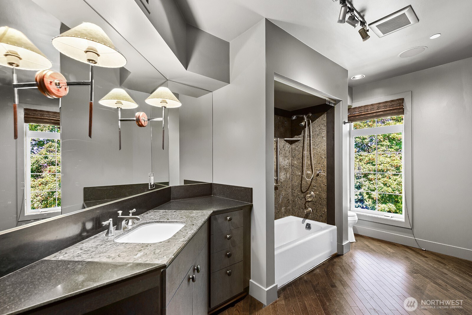 745 Bellevue Avenue East, Unit 402 Seattle, WA 98102 - Photo 24 of 39 a bathroom with a granite countertop sink a large mirror and a bathtub