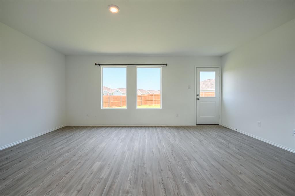 5916 Crystal Water Way Princeton, TX 75407 - Photo 11 of 28 an empty room with wooden floor and windows