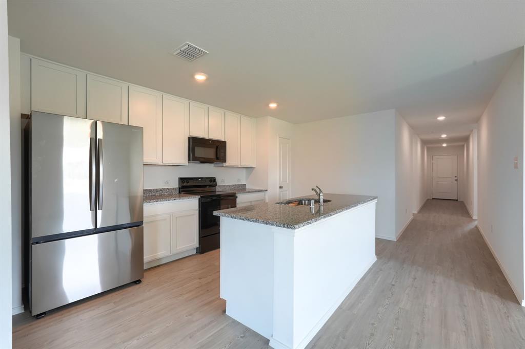 5916 Crystal Water Way Princeton, TX 75407 - Photo 4 of 28 a kitchen with a refrigerator a sink and a stove top oven
