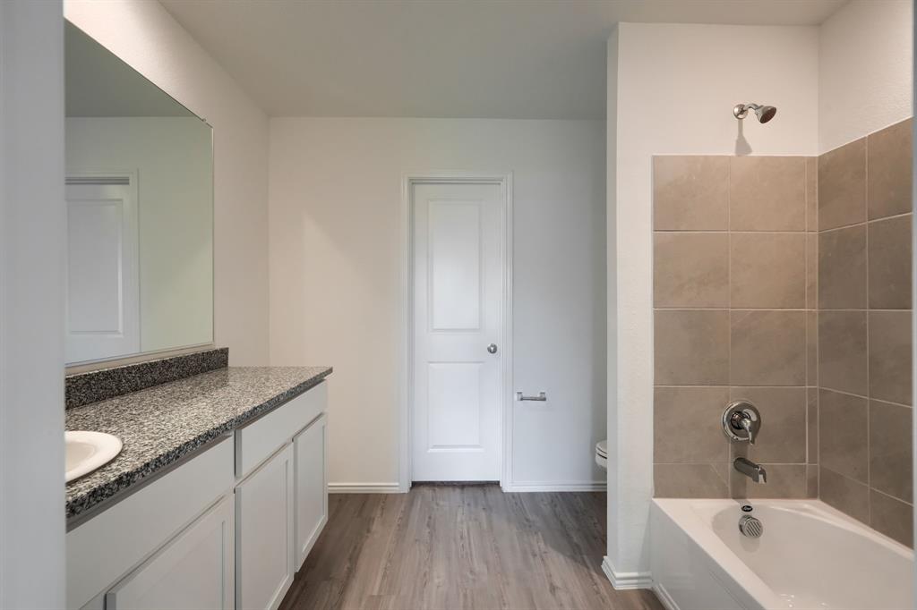 5916 Crystal Water Way Princeton, TX 75407 - Photo 7 of 28 a bathroom with a granite countertop sink a toilet and bathtub