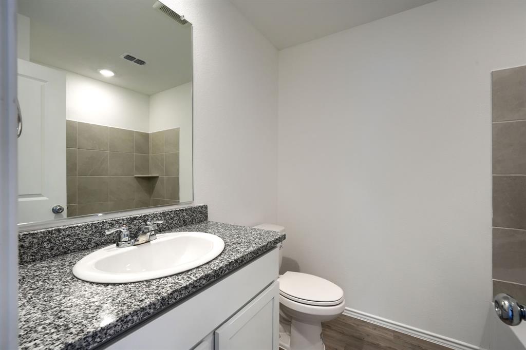 5916 Crystal Water Way Princeton, TX 75407 - Photo 8 of 28 a bathroom with a granite countertop sink a toilet and a mirror