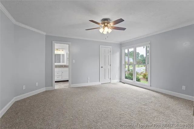 a view of an empty room with chandelier fan and fire place