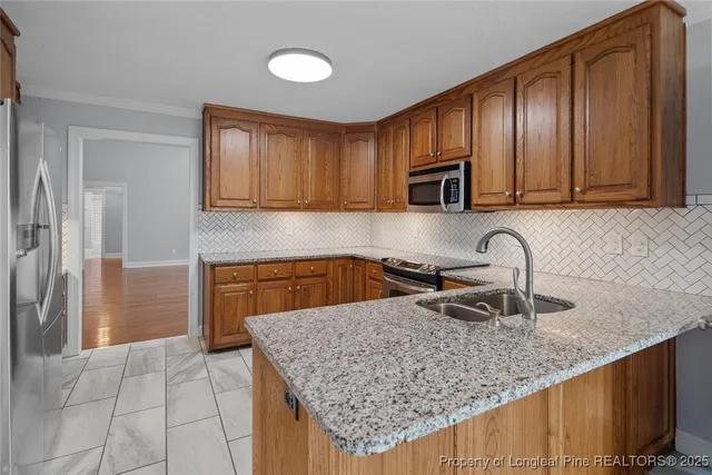a kitchen with granite countertop a sink a stove and a wooden cabinets