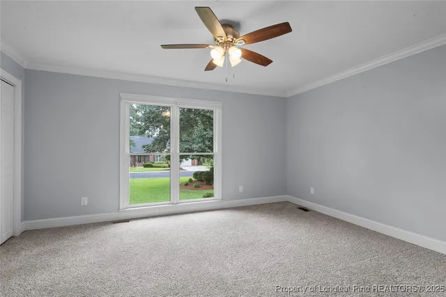 an empty room with a ceiling fan and a large window
