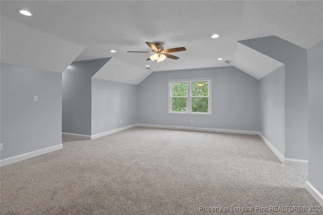 an empty room with a window and a ceiling fan