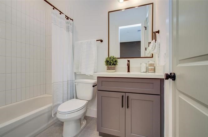 2309 Eagle Street Houston, TX 77004 - Photo 17 of 34 a bathroom with a granite countertop sink toilet a mirror and shower