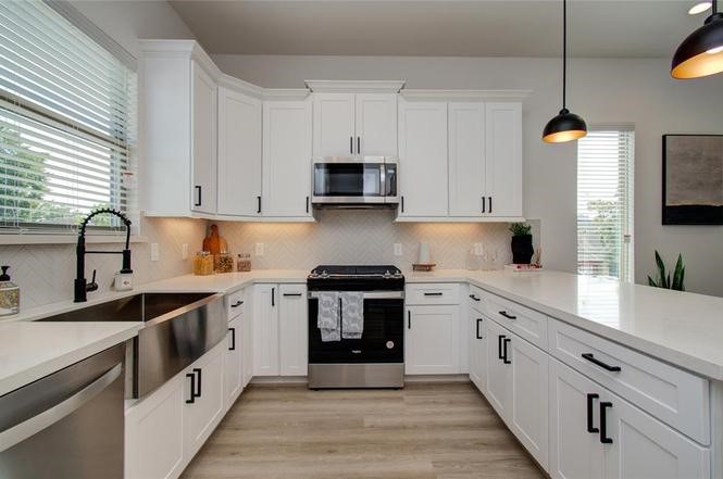 2309 Eagle Street Houston, TX 77004 - Photo 3 of 34 a kitchen with stainless steel appliances granite countertop a stove a sink and white cabinets