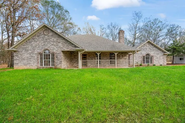 a view of a house with a yard and porch
