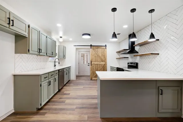 a kitchen with kitchen island a sink stove and wooden floor