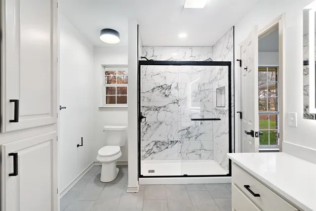 a bathroom with a shower toilet and sink