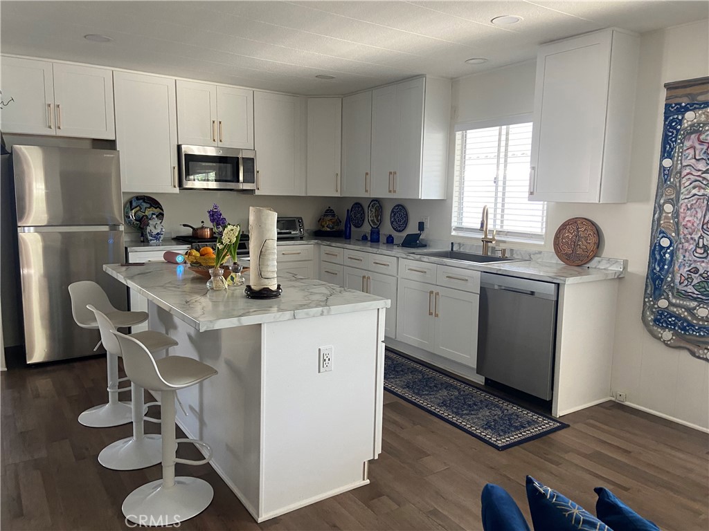 10210 Base Line Road Rancho Cucamonga, CA 91701 - Photo 1 of 13 a kitchen with a sink cabinets and wooden floor