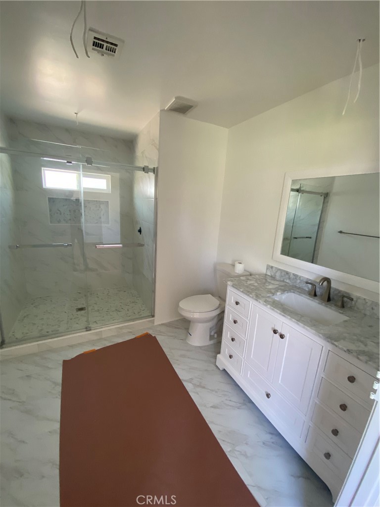 10210 Base Line Road Rancho Cucamonga, CA 91701 - Photo 12 of 13 a spacious bathroom with a granite countertop sink a toilet a shower and a mirror