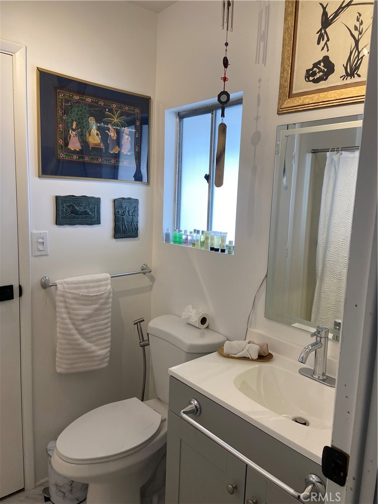 10210 Base Line Road Rancho Cucamonga, CA 91701 - Photo 6 of 13 a bathroom with a toilet a sink and mirror