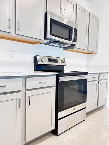 a kitchen with stainless steel appliances white cabinets a stove and a microwave