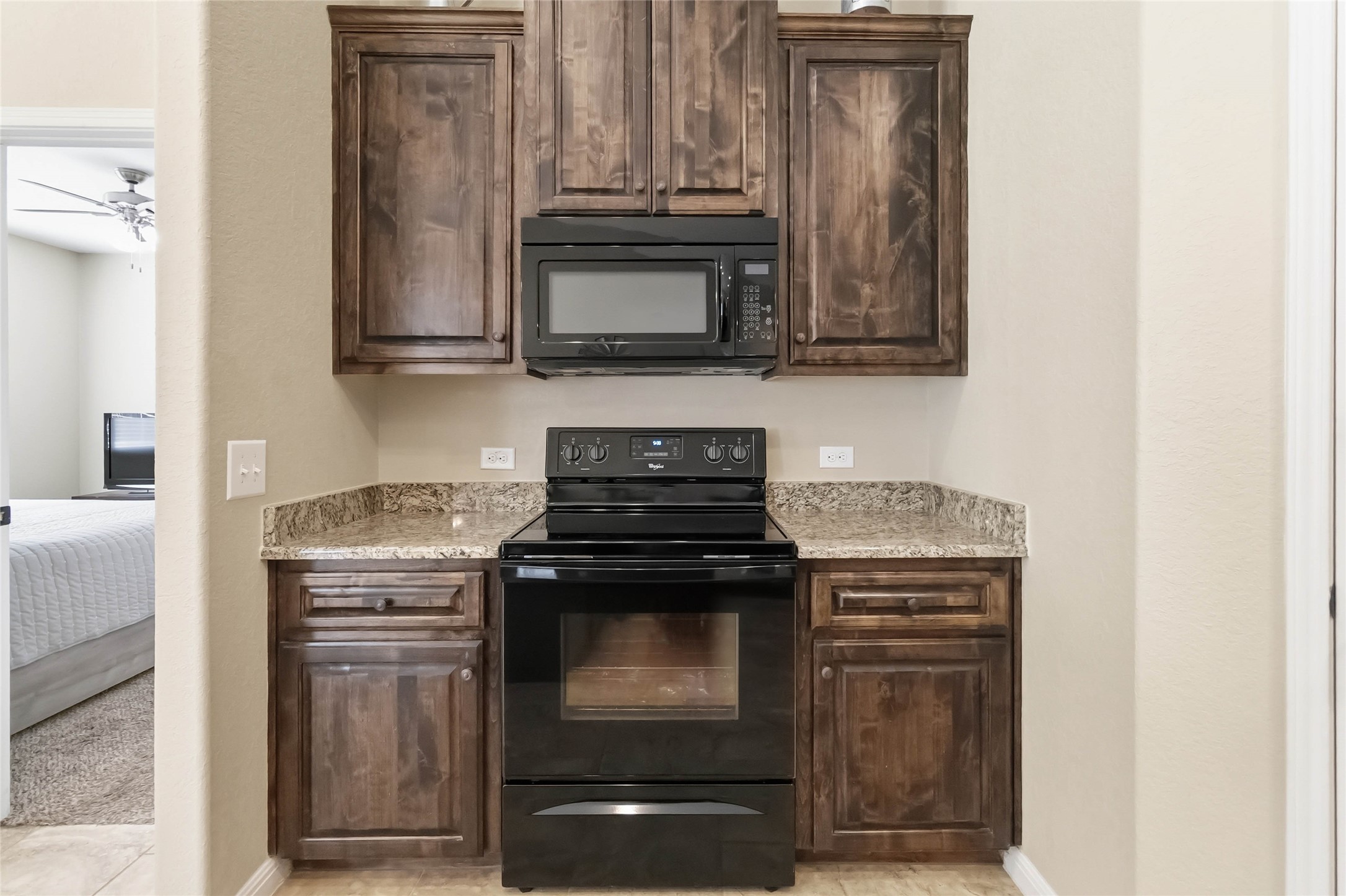 285 Hummingbird Way Martindale, TX 78655 - Photo 9 of 40 a kitchen with granite countertop a stove and a microwave