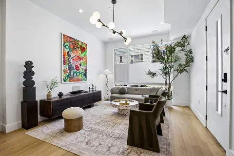 a dining room with furniture a chandelier and wooden floor